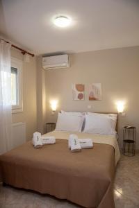 a bedroom with a bed with two towels on it at Utopia Inn in Néa Péramos