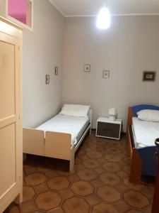 een kamer met 2 bedden en een nachtkastje bij Appartamento Vacanza Luna in Partinico