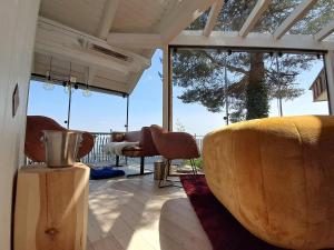a living room with a couch and chairs and windows at Piccolo Paradiso - Adults ONLY in Bodensdorf