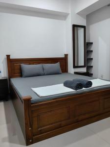 a bed with a wooden frame and a mirror at Oval View by CityScape in Colombo