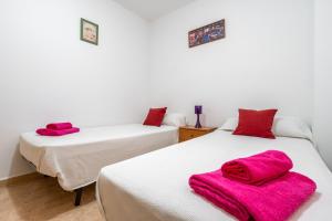 two beds in a room with pink towels on them at Ca la Mercè in Camarles +9 photos