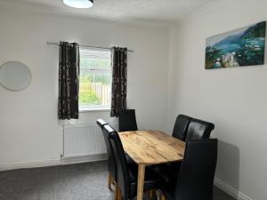 a dining room with a wooden table and black chairs at Blyth Royal, Free Parking in Bebside +6 photos