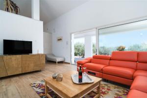Una sala de estar con un sofá rojo y un televisor. en Villa Piricone, en Orosei