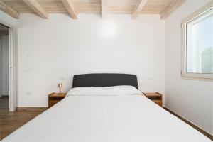 Un dormitorio blanco con una cama y una ventana. en Villa Piricone, en Orosei