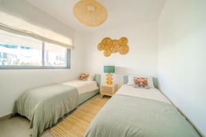 two beds in a room with a window at Sea Views Apartment Lucy in Fuengirola +21 photos