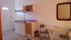 a kitchen with a sink and a table and a mirror at Pefki Apartment 4 in Artemísion