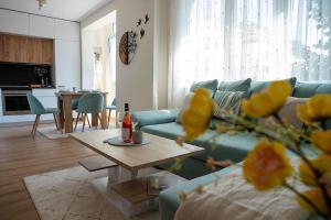 a living room with a blue couch and a table at Holiday Apartment Town Centre in Kazanlŭk
