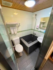 a bathroom with a toilet and a tub and a sink at Dealer Hotel in Taipei