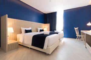 a bedroom with a large bed with blue walls at Klub Hotel Bangkok in Bangkok +176 photos