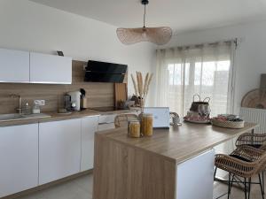 a kitchen with white cabinets and a wooden counter top at Bienvenue chez nous in Noisy-le-Grand