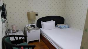 a small bedroom with a bed and a telephone at Awesome Hotel in Shulin