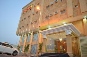 a white car parked in front of a building at Holiday Season in Tabuk