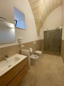a bathroom with a sink and a toilet at Agriturismo Masseria Sbotta in SantʼAndrea +71 photos