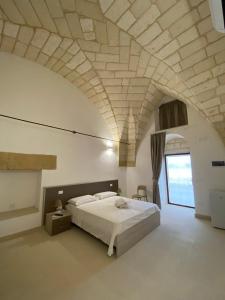 a bedroom with a large bed in a room with an attic at Agriturismo Masseria Sbotta in SantʼAndrea
