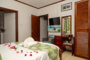a bedroom with a bed with flowers on it at Pension Hibiscus in La Digue +49 photos