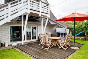 a patio with a table and chairs and an umbrella at Wellness Ferienwohnung Müller in Rostock