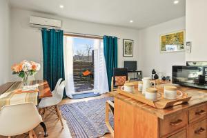 un soggiorno con tavolo, sedie e una finestra di The Orange Cottage a Hamilton