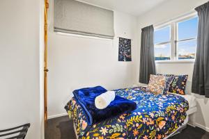 una piccola camera da letto con un letto e una finestra di The Orange Cottage a Hamilton