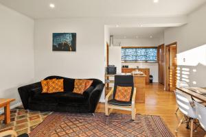 un soggiorno con un divano e un tavolo di The Orange Cottage a Hamilton Altre 14 foto