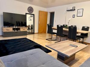 ein Wohnzimmer mit Sofa, Tisch und Stühlen in der Unterkunft tas24ch Travel and Sleep 24 in St. Gallen