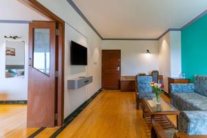 a living room with a couch and a table at Sterling Karwar in Kārwār
