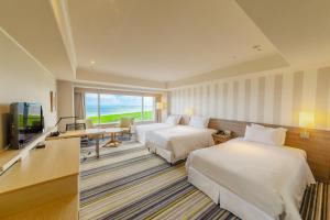 a hotel room with two beds and a flat screen tv at Sheraton Grande Ocean Resort in Miyazaki