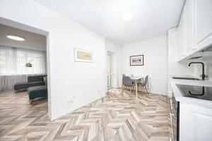 a kitchen and dining room with white walls and wooden flooring at Apartment in Trakai by the lake! in Trakai +6 photos