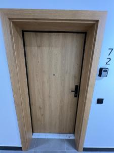 a wooden door in the middle of a room at Mikołowska Small Heaven - free underground parking in Katowice
