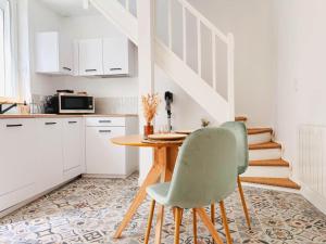 a kitchen with a wooden table and two chairs at La Casa Laura, Balnéo & Terrasse Privée in Étaples
