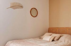 a bedroom with a bed with a mirror on the wall at La Casa Laura, Balnéo & Terrasse Privée in Étaples