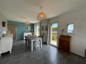 eine Küche und ein Esszimmer mit Tisch und Stühlen in der Unterkunft Ar Parc Bihan, vue mer! in Audierne