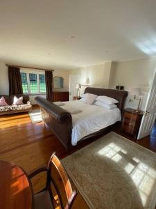 a bedroom with a bed and a table and chairs at Picturebook cottage on prestigious polo estate in Stedham