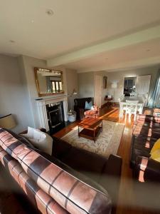 a living room with a couch and a living room with a table at Picturebook cottage on prestigious polo estate in Stedham