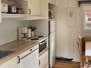 a kitchen with a white refrigerator and a stove at 4 star holiday home in LJUSTERÖ in Norra Ljustero