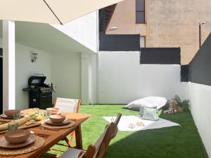 un salon avec une table et de l'herbe verte dans l'établissement VillaHomes, à Villanueva de la Vera