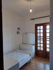 a bedroom with a bed and a dresser and a door at Psakoudia old olive trees appartment 50 m2, 2 bedrooms, sea view in Psakoudia