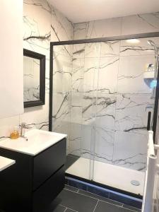 a bathroom with a shower and a sink and a tub at #7 Appartement pour 5 personnes près du métro L9 in Bagnolet