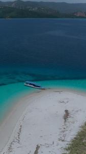 a boat in the water next to a beach at Boat Trip in Riung
