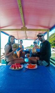 a group of people sitting on a boat eating watermelon at Boat Trip in Riung