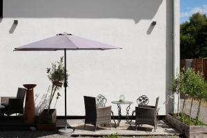 a patio with an umbrella and chairs and a table at Ferienoase Im Land Der 1000 Seen in Karstädt
