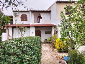 a white house with a gate and a yard at Daddos in Flumini di Quartu