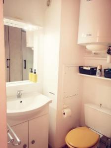 une salle de bain blanche avec un lavabo et des toilettes dans l'établissement Appartement 600M de la plage, à Port-la-Nouvelle