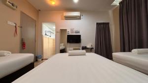 瓜拉丁加奴Ada Hotel & Apartment的有两张床和一台电视的酒店房间