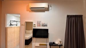 瓜拉丁加奴Ada Hotel & Apartment的一间配有电视的房间和一间配有床的房间