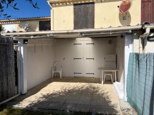 a garage with a table and a chair on a patio at Pavillon chez Michel corse in Poggio-Mezzana +7 photos