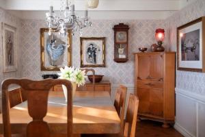 a dining room with a table and a chandelier at Koselig gammelt gårdstun in Stavanger