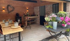 a patio with tables and potted plants on it at La Roseraie in Tournai