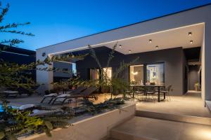 a modern house with a patio at night at Villa M in Vodice