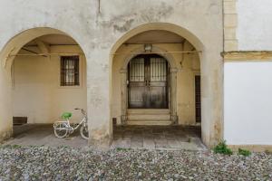 a bike parked in front of a building with two arches at Yourbanflat Clock Tower in Padova
