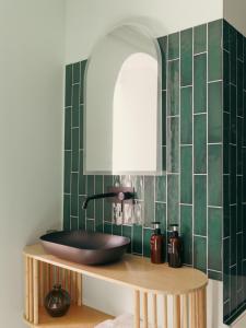 ein Badezimmer mit einem Waschbecken auf einer Ablage mit grünen Fliesen in der Unterkunft Alcova - Stade de France - Jacuzzi - Cinema in Saint-Denis + 9 Fotos